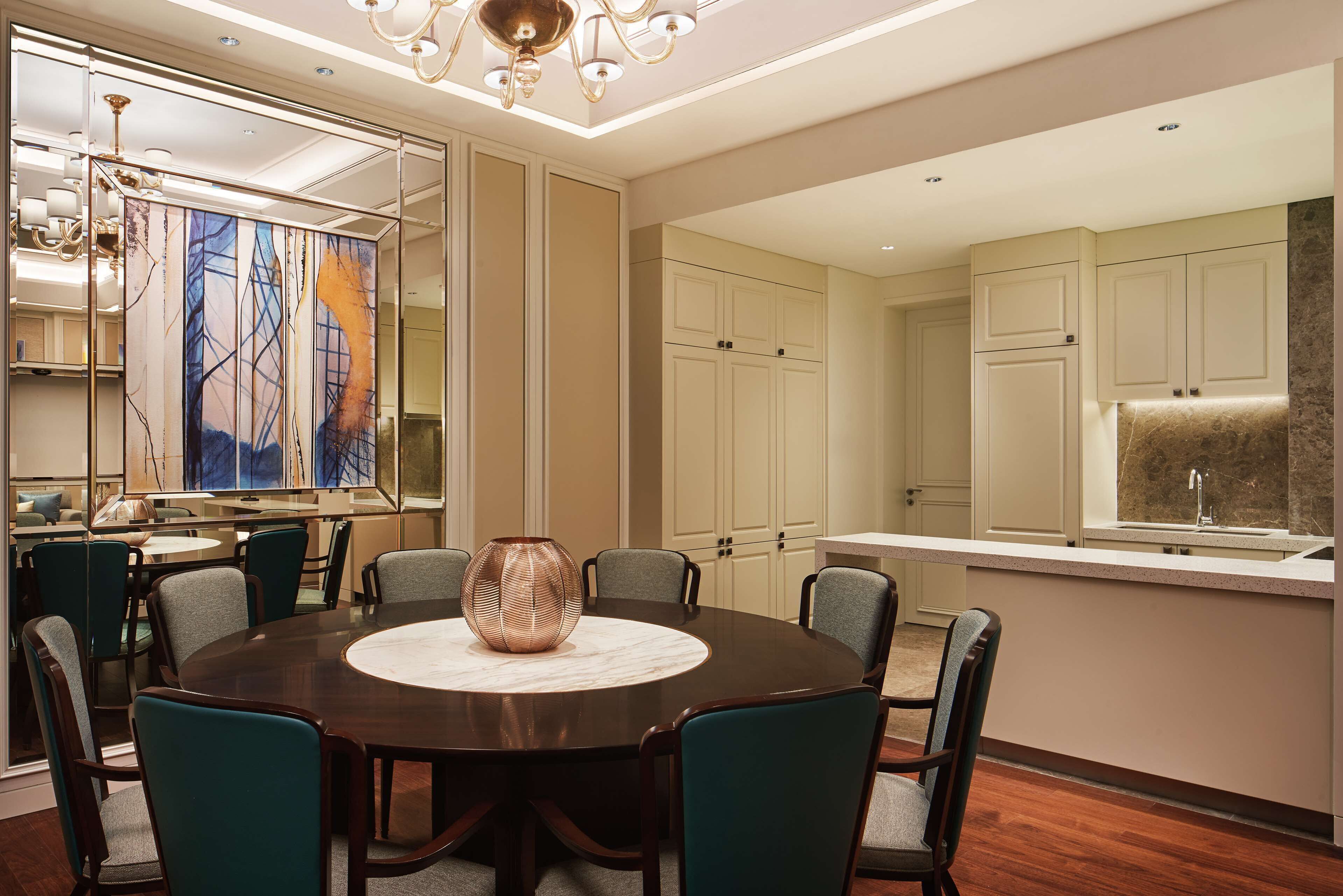 A modern dining area with a round table, chairs, and a large vase.