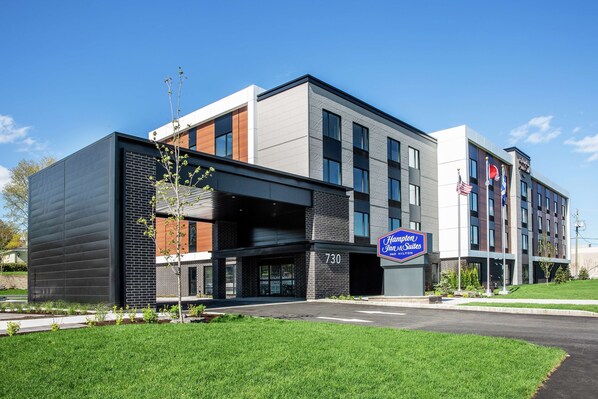A modern hotel with a flat roof, large windows, and a sign indicating it is a Hampton Suites hotel. - Hampton Inn & Suites by Hilton Quebec City Beauport (Québec City)