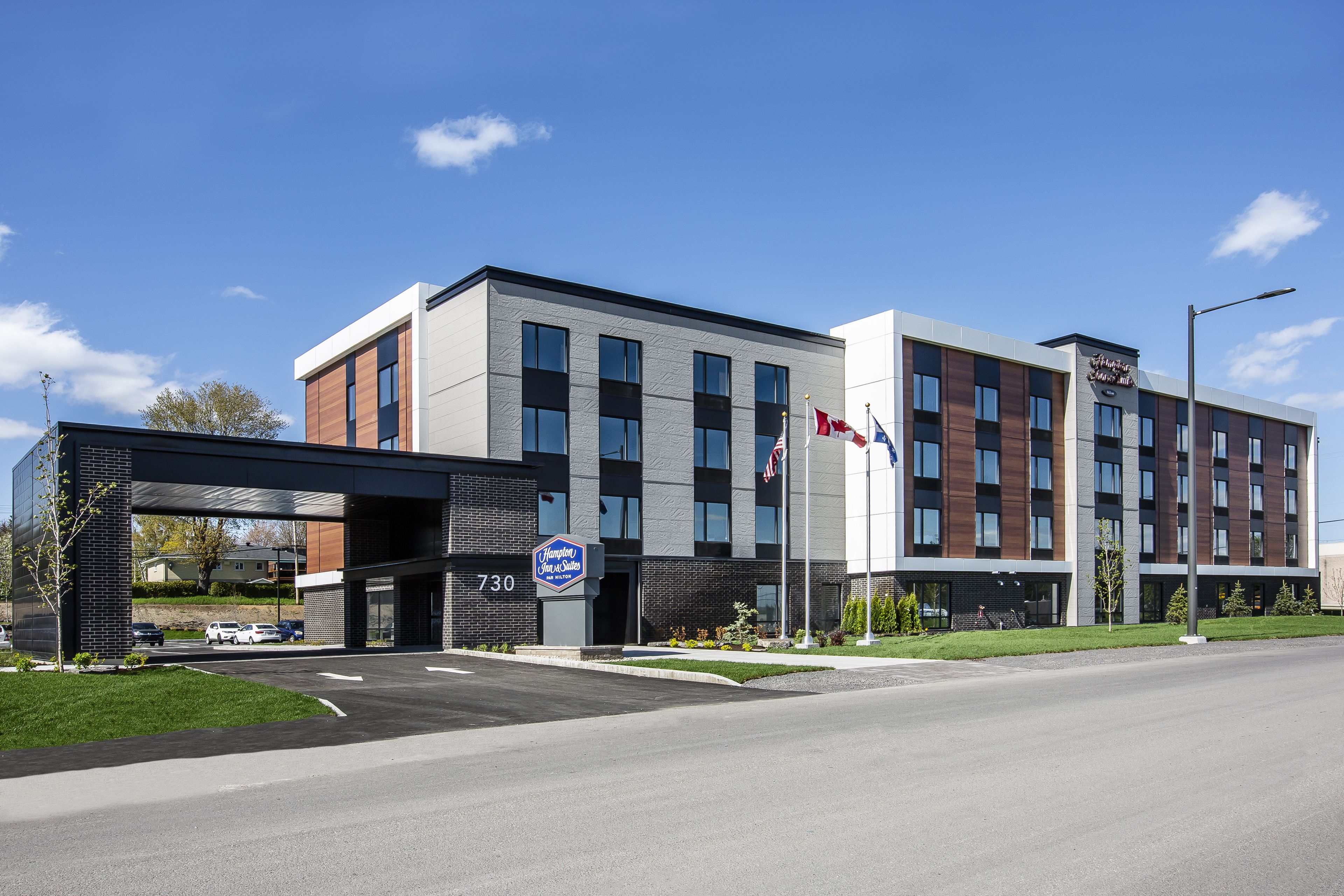A modern hotel with a two-story structure, a covered entrance, and a parking lot.