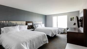 Habitación de hotel con dos camas, un ventanal grande, un cuadro en la pared y un escritorio con una silla.