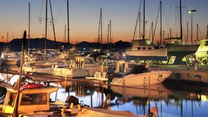 A marina with multiple boats docked, calm water, and a mountainous backdrop. - Llevant - Beautiful villa with pool in Can Picafort (Can Picafort)