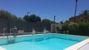 A rectangular swimming pool with a light-colored deck surrounding it. - villa in San Leone with swimming pool (san leone agrigento)
