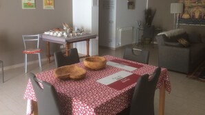 A dining area with a table set for four, a gray sofa, and a painting on the wall. - villa in San Leone with swimming pool (san leone agrigento)