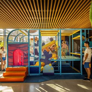 An indoor play area with a climbing wall, slides, and netted play structures. - Marea Valamar Collection Suites (Porec)