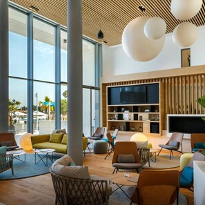 A spacious lobby with large windows, a modern ceiling design, and a variety of seating arrangements. - Marea Valamar Collection Suites (Porec)