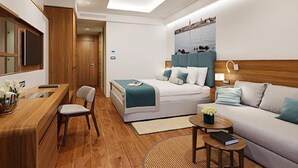 A modern hotel room with a bed, a desk, a chair, a sofa, and a small table. - Marea Valamar Collection Suites (Porec)