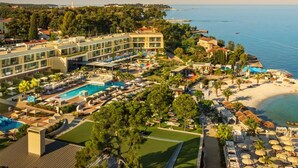 A resort with a swimming pool, beach, and a view of the sea. - Marea Valamar Collection Suites (Porec)