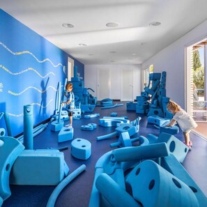 A playroom with blue play structures and a child playing. - Marea Valamar Collection Suites (Porec)