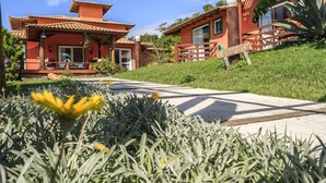 A traditional red-roofed building with a paved pathway leading to the entrance. - Pousada Caminho das Aroeiras (Búzios)