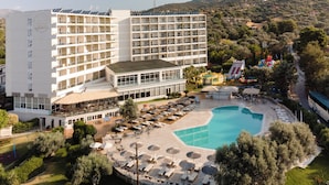 A resort with multiple floors, outdoor pool, and sun loungers.