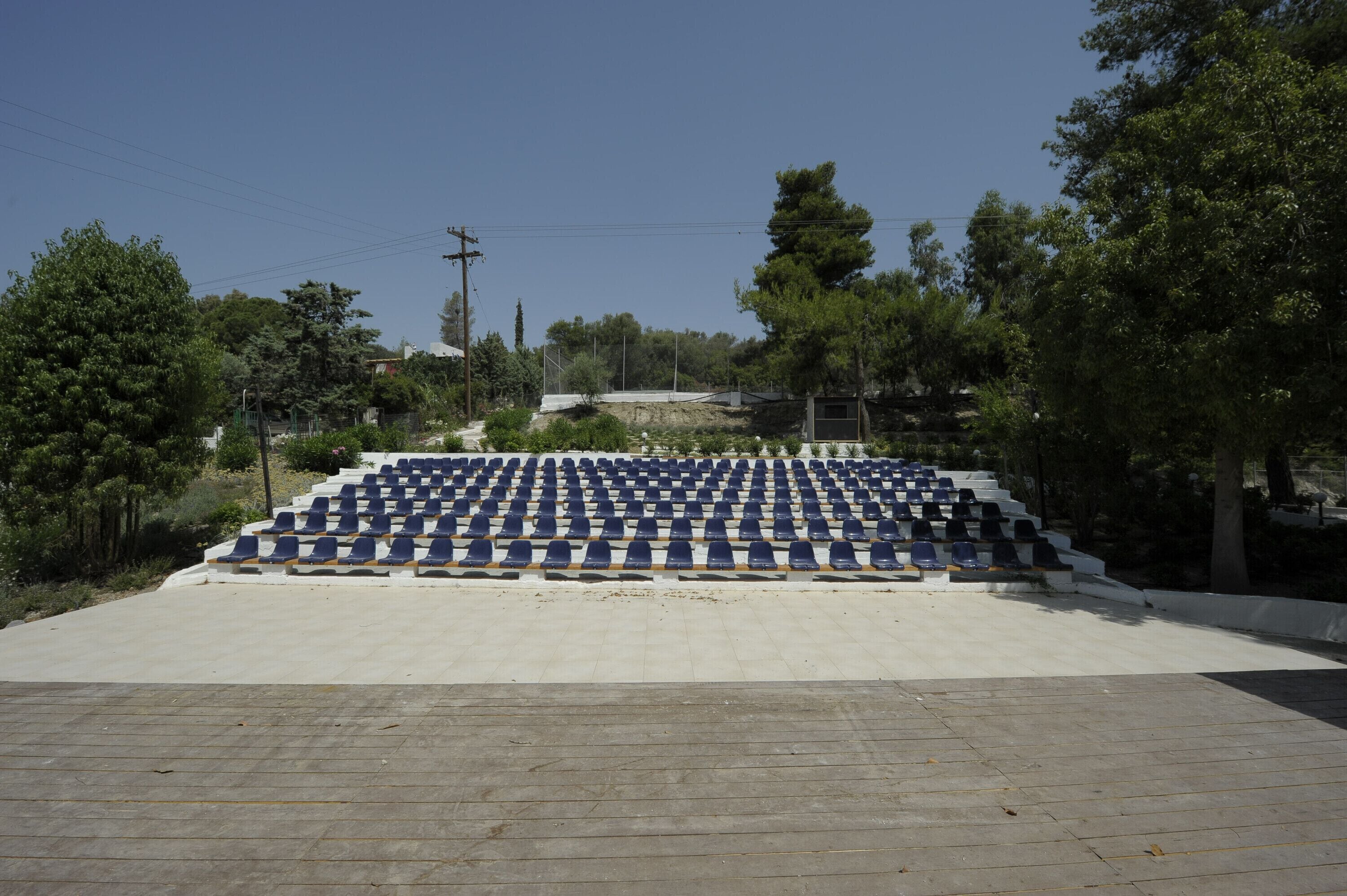 A large outdoor amphitheater with tiered seating and a paved floor.
