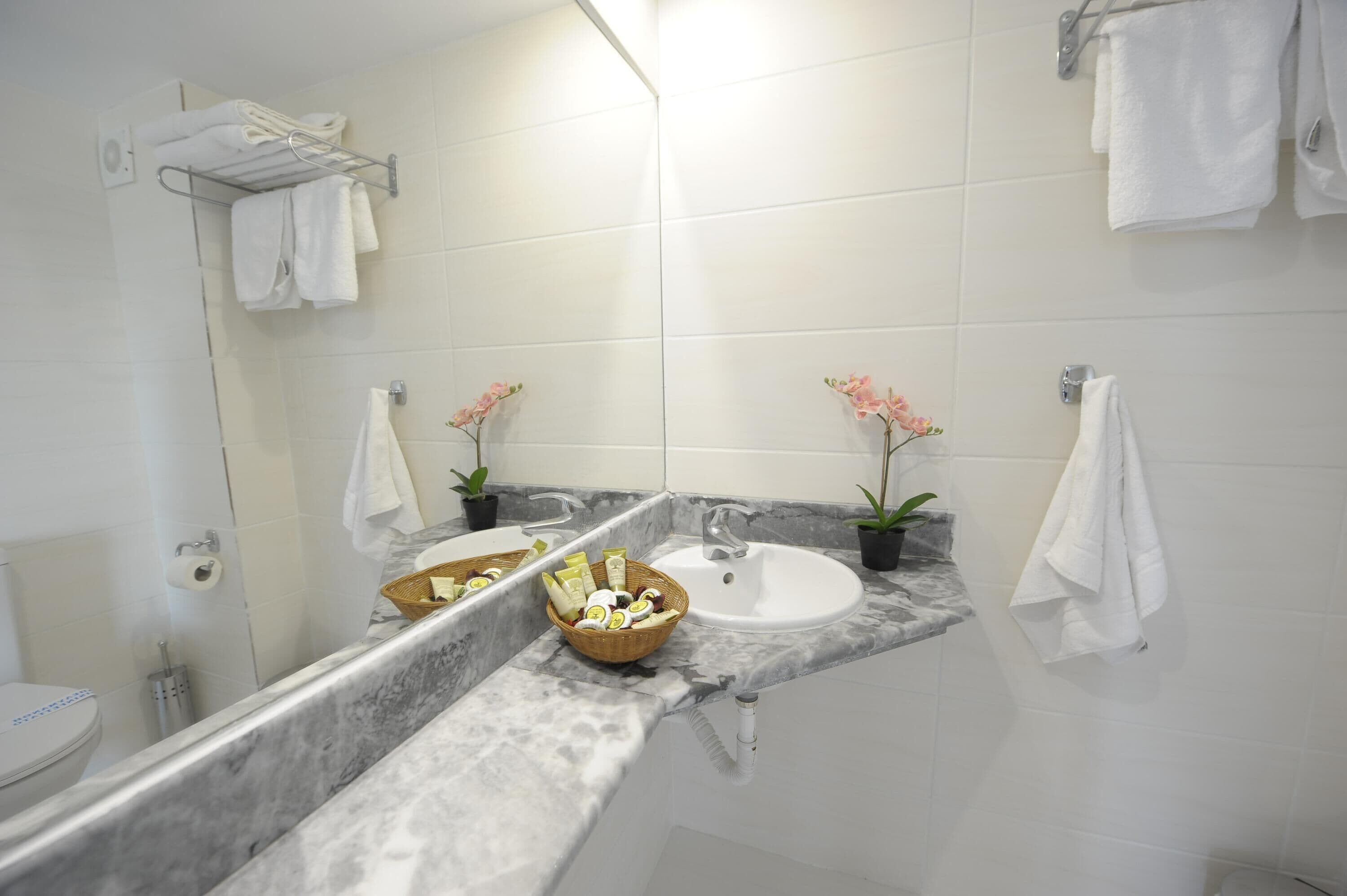 A bathroom with two sinks, a mirror, and a towel rack.