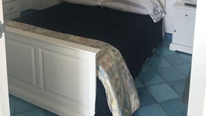 A bedroom with a bed, a nightstand, a lamp, and a dresser. - Residenza Sveva (Ravello)