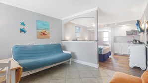 A compact living space with a sofa, a dining table, and a kitchenette.