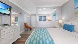 A hotel room with a bed, a TV, a chair, a desk, and a window.