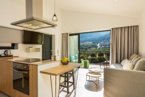 A modern kitchen with a large window and a balcony. - T Hotel Premium Suites (Mylopotamos)