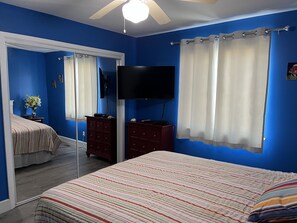 Cozy retreat with a bed, flat-screen TV, and dresser, perfect for a relaxing stay.