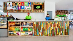 Eine moderne Snackbar mit einer farbenfrohen Holzverkleidung, einem Bildschirm und einer Auswahl an Snacks.