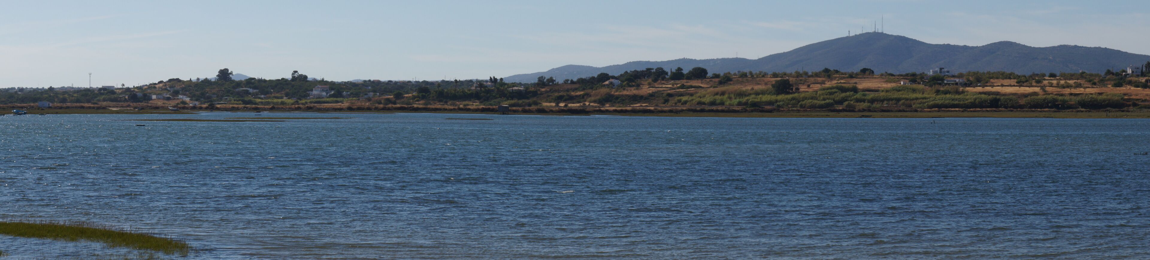 Un lago tranquilo con una montaña al fondo.