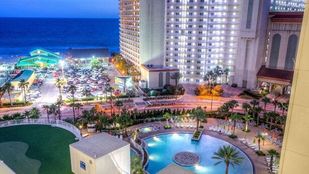 A hotel with a large pool, a parking lot, and a view of the ocean. - Lake Front-Private Beach Access- Golf - all within walking distance (Panama City)