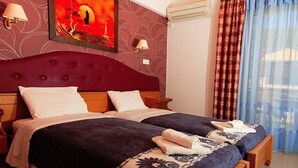 A double bed with a red headboard, two bedside tables, and a wall-mounted lamp. - Cosmopol Lefkada (Lefkada)