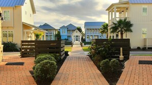 A pathway leading to a building with a covered walkway and a small structure in the center. - Cinnamon Shore- Porter Ansas TC 3302 (Port Aransas)