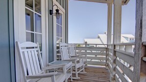 A wooden deck with white rocking chairs and a railing. - Cinnamon Shore- Porter Ansas TC 3302 (Port Aransas)