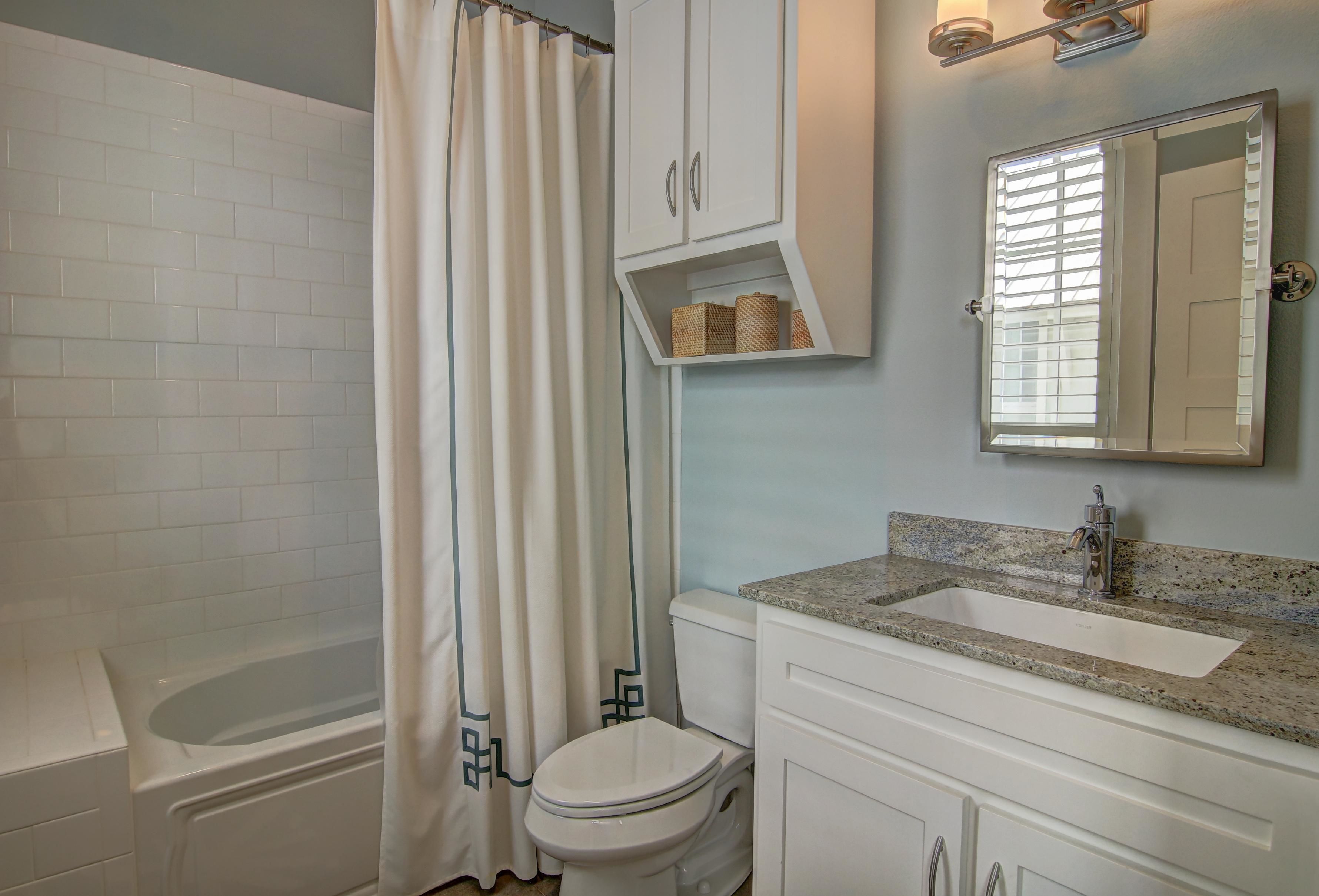 Une salle de bain comprenant une baignoire, des toilettes, un meuble-lavabo et un miroir.