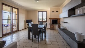 A dining area with a table and chairs, a fireplace, and a TV.