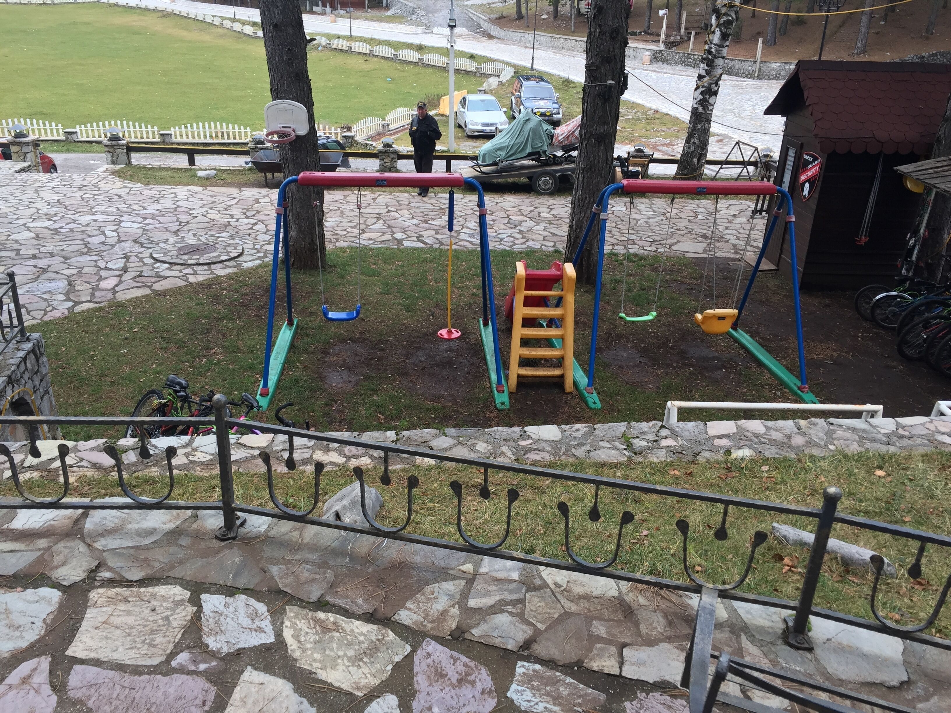 Un patio de juegos con columpios, un tobogán y una estructura para escalar.