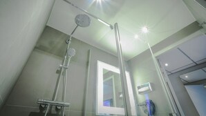 A modern bathroom with a glass shower enclosure, a visible toilet, and a mirror. - Arena Hotel La Defense (Nanterre)
