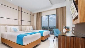 A modern hotel room with two beds, a desk, and a view of the city. - Dafam Lotus Jember Hotel (Jember)