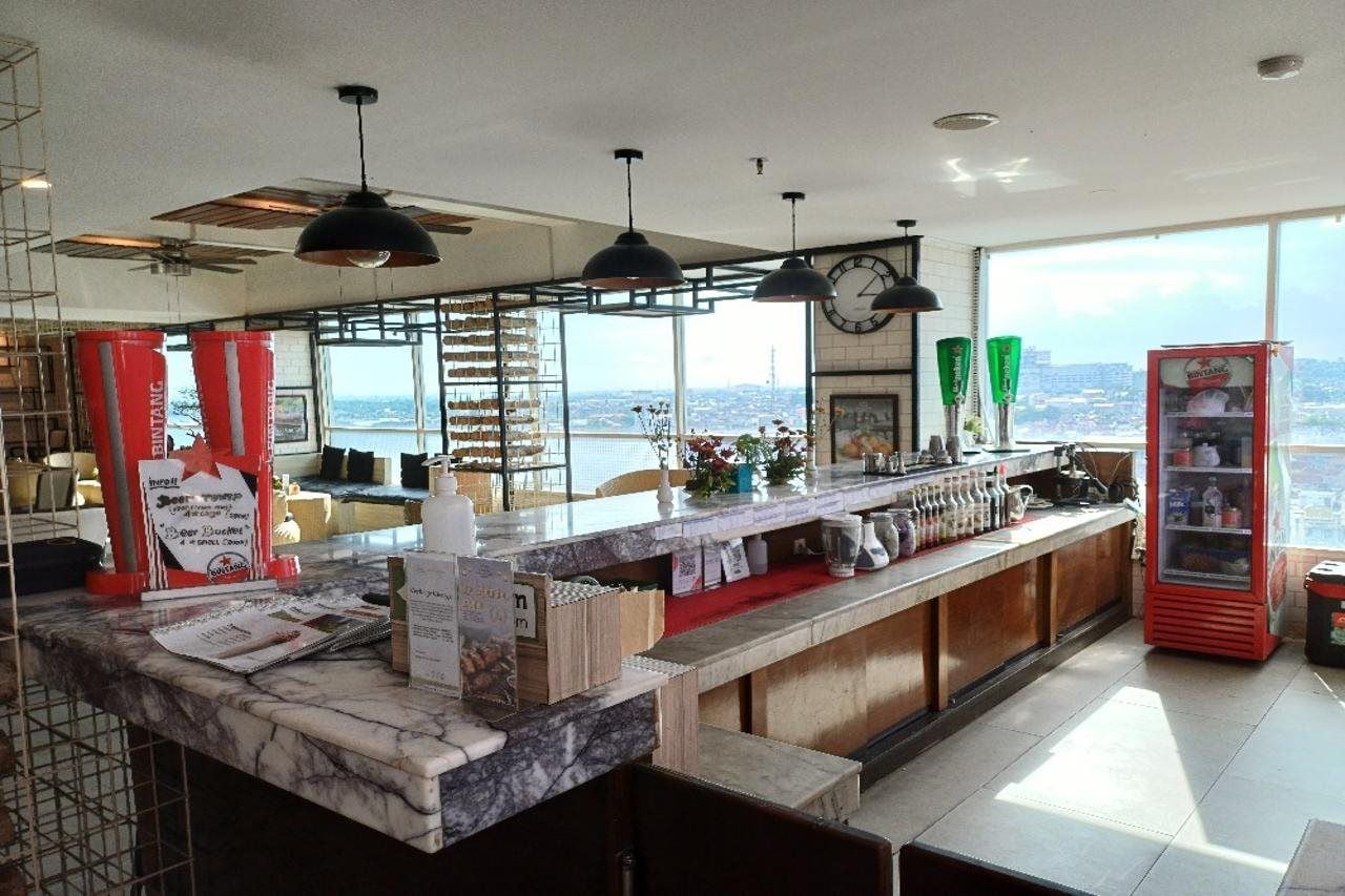 Una cocina moderna con encimera de mármol, un reloj y vistas a la ciudad.