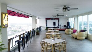 A spacious indoor area with high ceilings, a stage with musical equipment, and seating arrangements. - Dafam Lotus Jember Hotel (Jember)