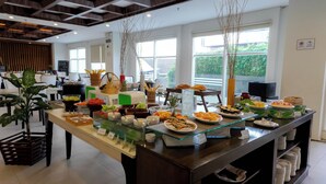 A buffet setup with various food items and a glass display case. - Dafam Lotus Jember Hotel (Jember)