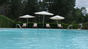 Une piscine avec des chaises longues et des parasols.