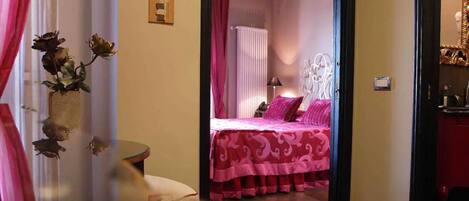 A bedroom with a bed, a bedside table, and a mirror.