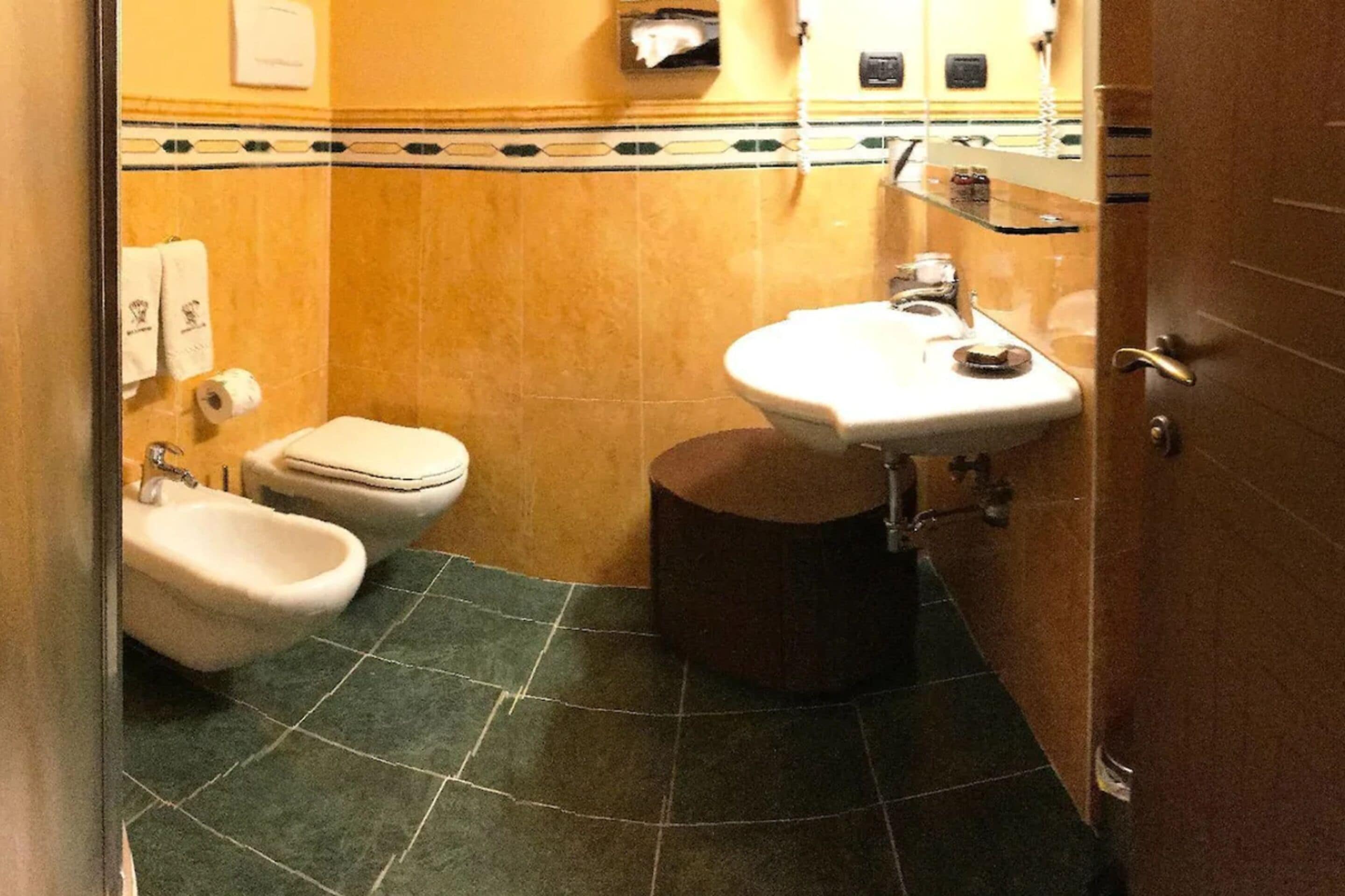 A small bathroom with a toilet, bidet, and sink.