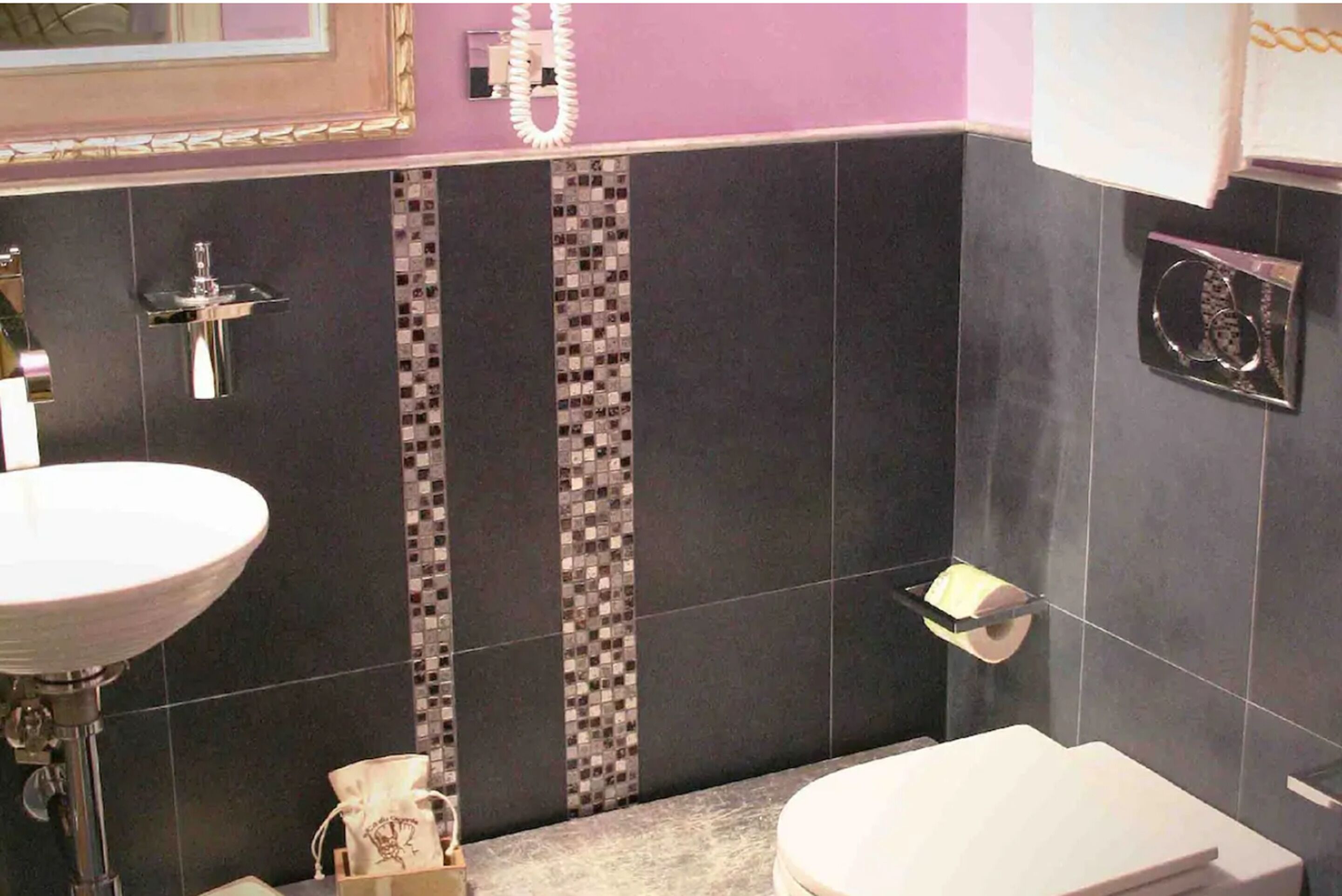 Un bagno con lavandino bianco, un water e una zona doccia.