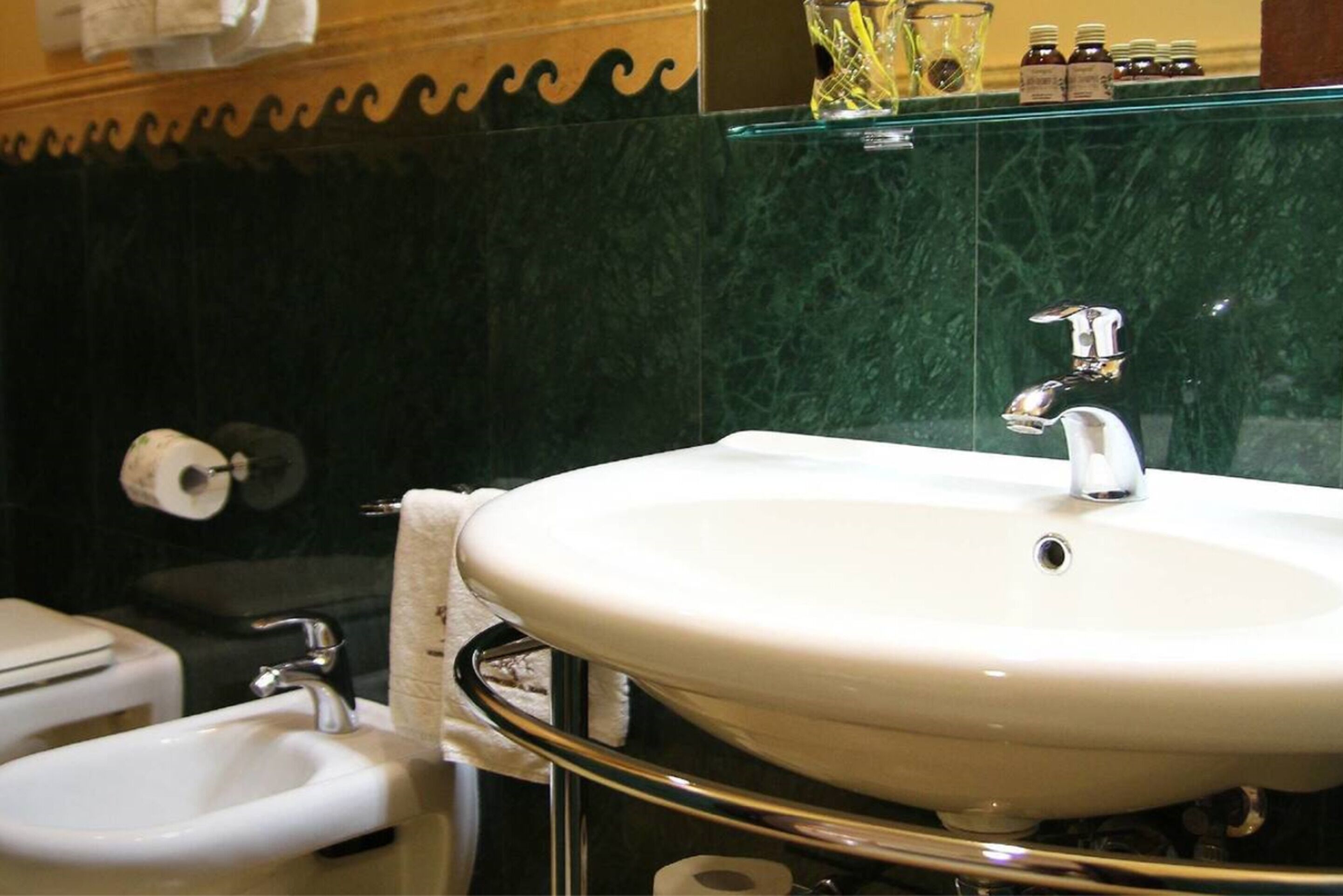 A bathroom with a white sink, a mirror, and a toilet.