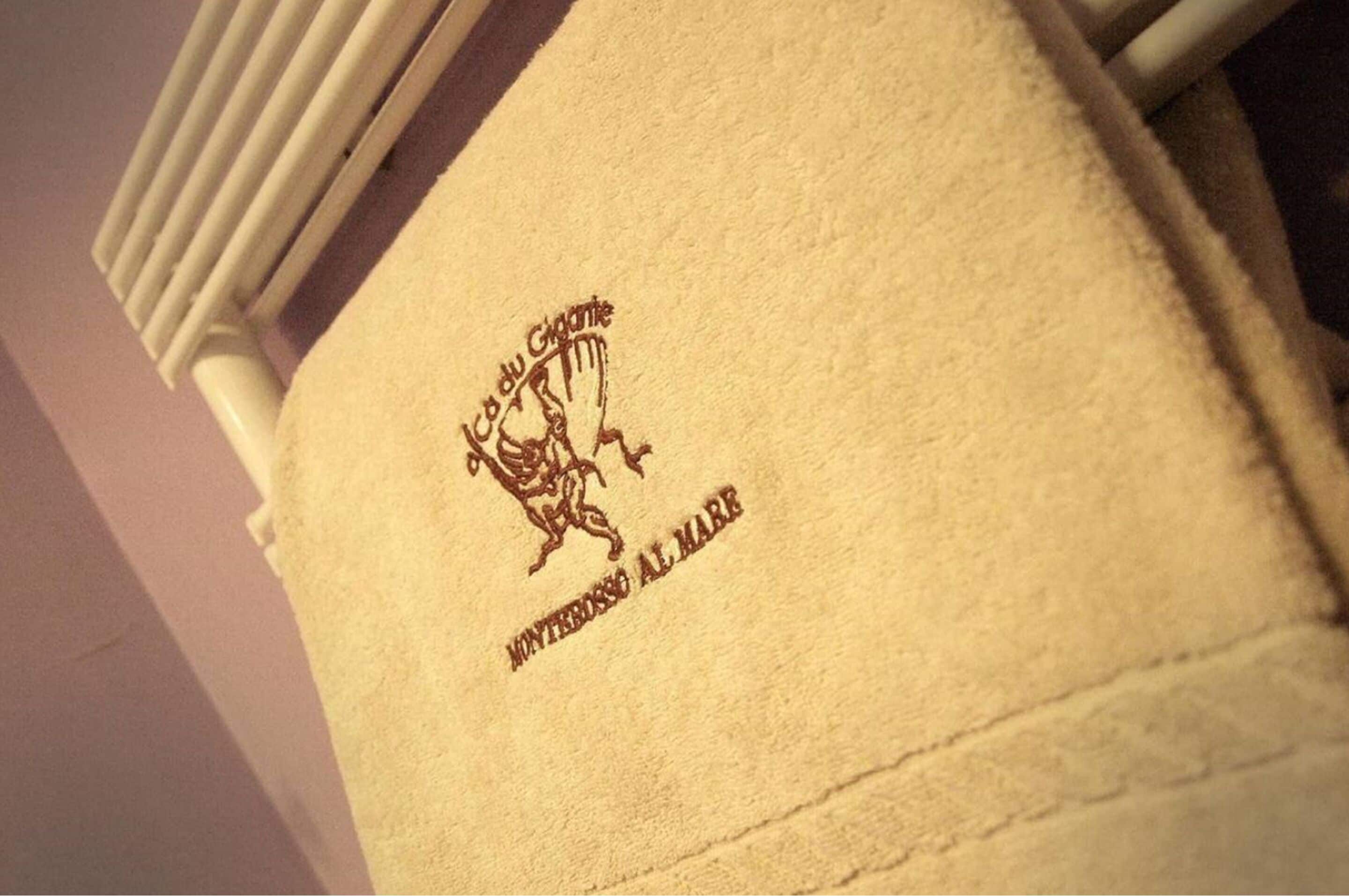 Una toalla con un logotipo y texto que indica que pertenece a un hotel.