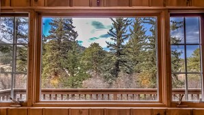 A window with a view of a forested area. - Mountain Cabin Overlooking Breathtaking Riverfront and Valley Views  (Estes Park)