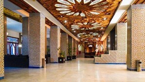 Un vestíbulo amplio con paneles ornamentales de madera y columnas estampadas.