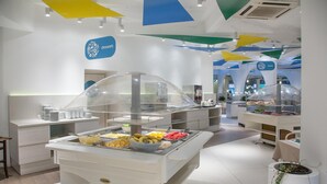 A buffet area with a variety of food items, a clear glass partition, and a sign indicating a dessert section. - Slovenska Plaza Resort 4 (Budva)