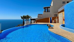 A modern hotel with a pool overlooking the sea, featuring a curved design and a clear view of the ocean. - Ático Vistamar X2113 - Benitachell, Costa Blanca (Benitachell)