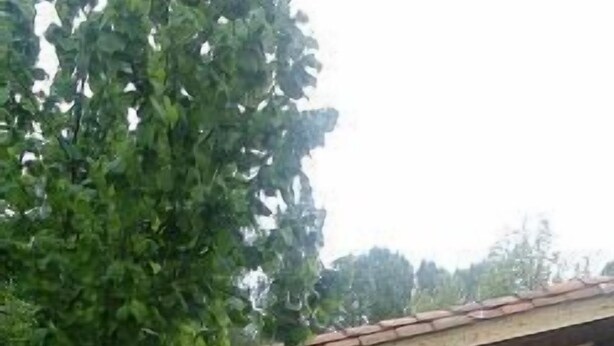 Un espacio de patio al aire libre con una pérgola, mesas y sillas.