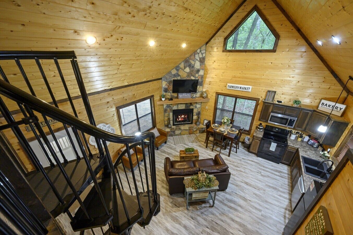 A spacious loft-style room with a fireplace, a dining area, and a kitchen.