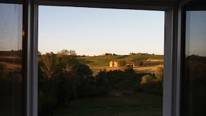 A view from a window overlooking a swimming pool and a vineyard landscape. - Moscato apartment relax and culture (Nizza Monferrato)