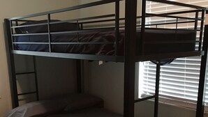 Uma cama beliche com uma cama inferior e um colchão no chão.