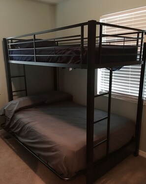 Una cama litera con una cama inferior y un colchón en el suelo.